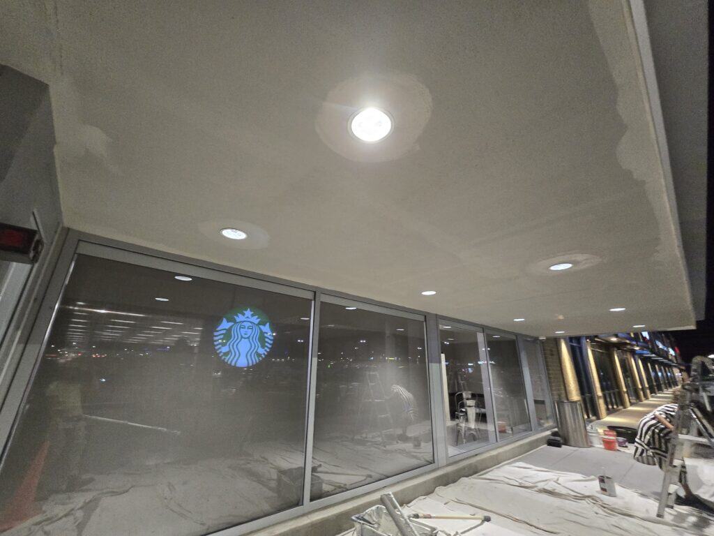 PaintWerks repairing damaged ACM canopy panels and repainting the underside with Sherwin-Williams Emerald at Target New Albany.
