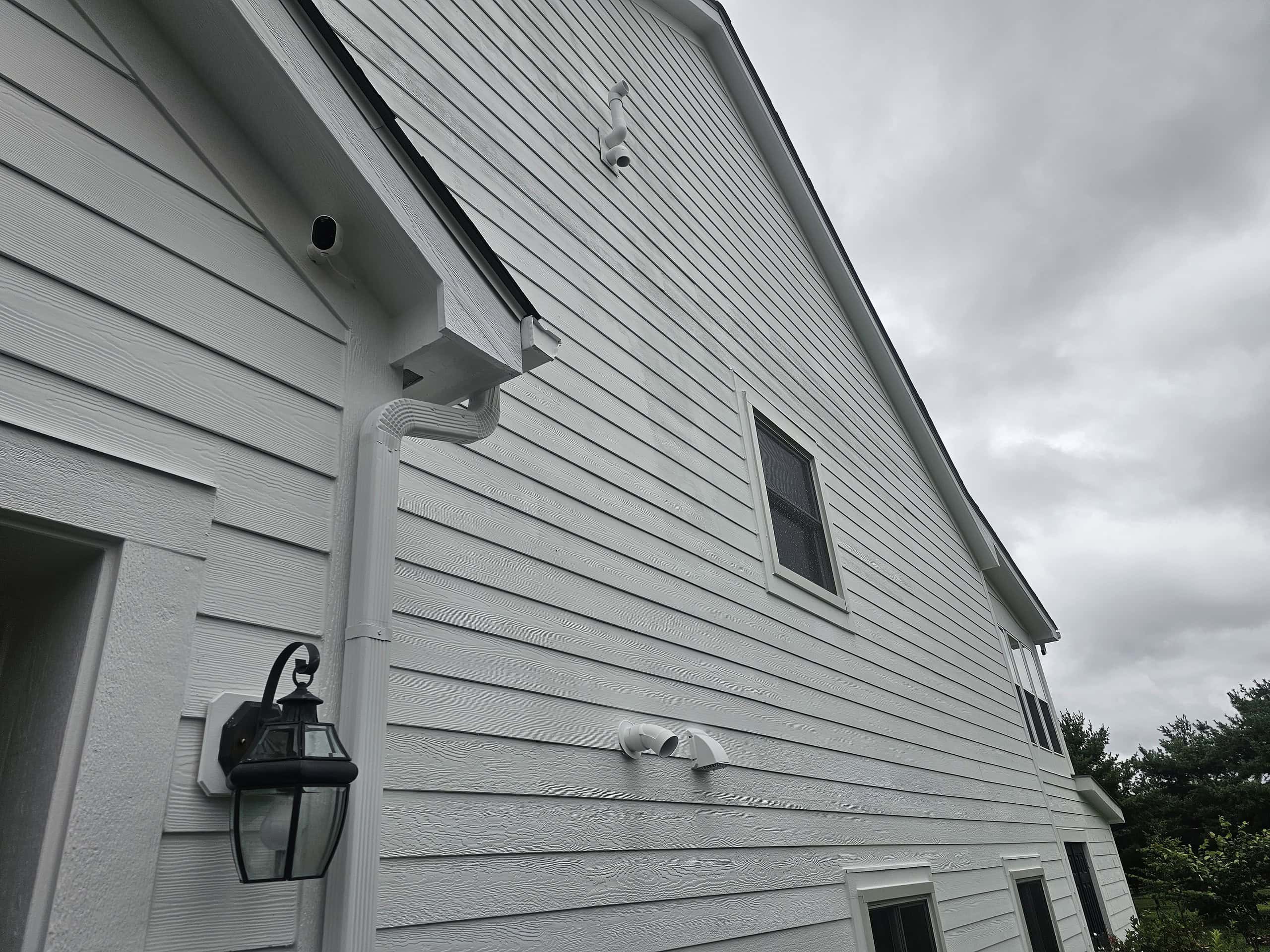 Bright white house siding with updated trim and gutters, reflecting top-quality painting work.