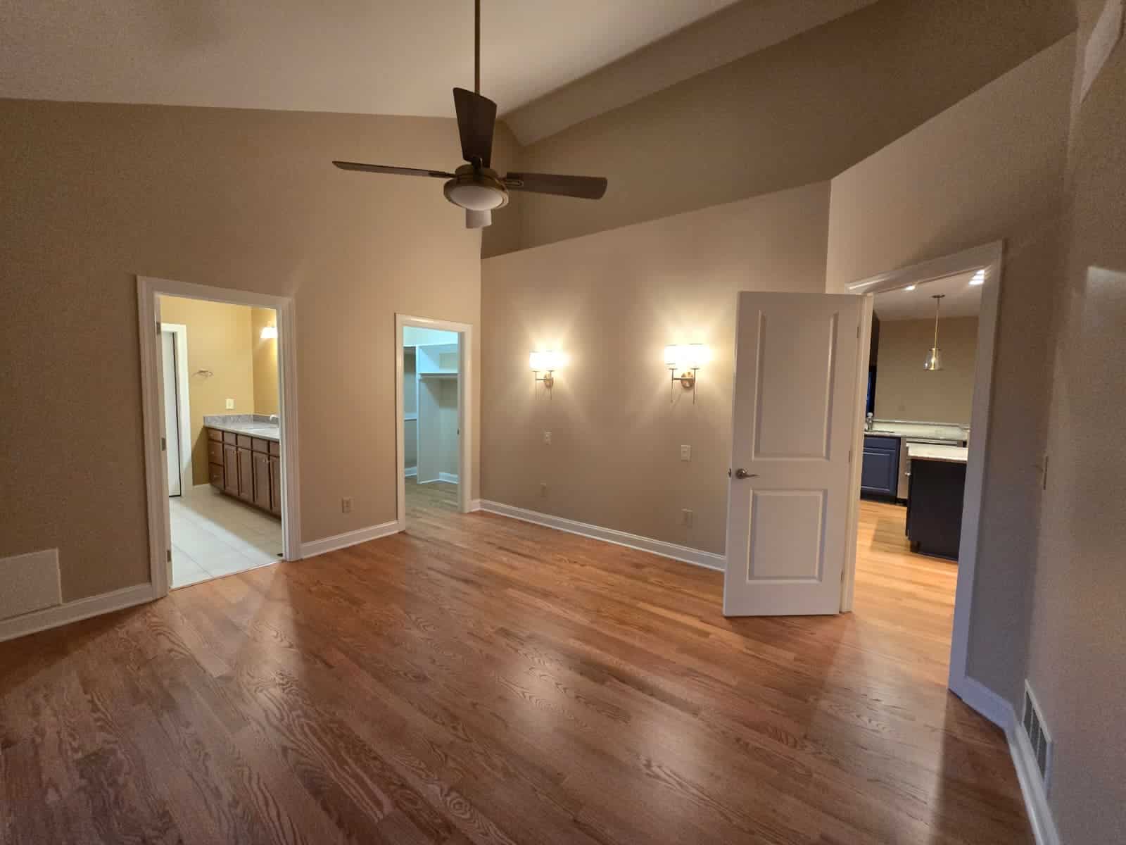 Bright, well-lit living room interior with freshly painted walls, ceiling fan, and open kitchen view in Columbus home.