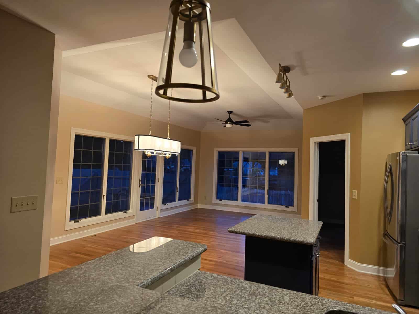 Bright and modern kitchen with freshly painted walls, hardwood floors, and contemporary lighting.