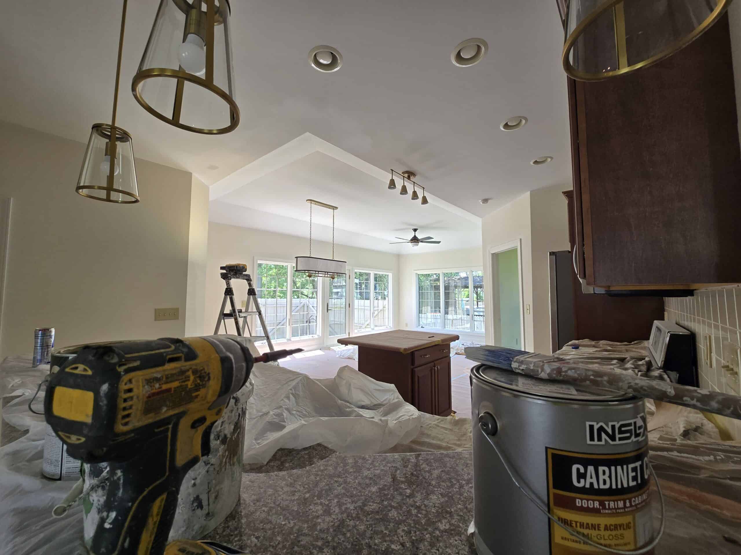 Dublin Ohio kitchen cabinet refinishing in progress — INSL-X Cabinet Coat being applied, ladder, dark island being painted